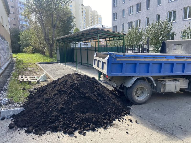 Выгрузка грунта во дворе многоквартирного дома под благоустройство